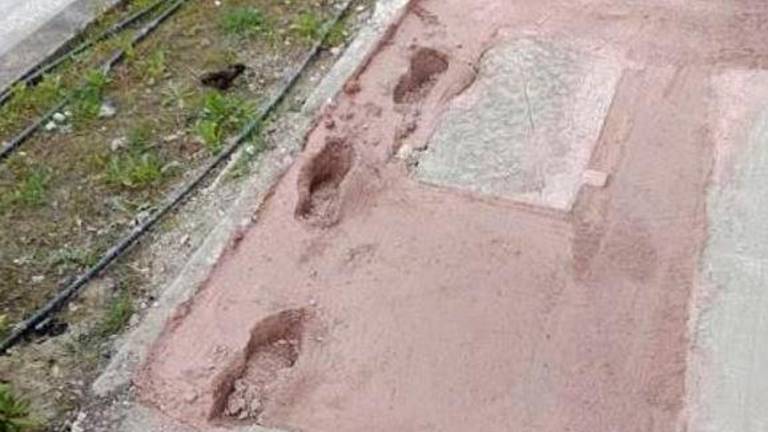 Un rattoppo stradale con segni di impronte Un rattoppo stradale con segni di impronte
