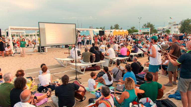 Rimini. In spiaggia a cantare con il vescovo per la pace Rimini. In spiaggia a cantare con il vescovo per la pace