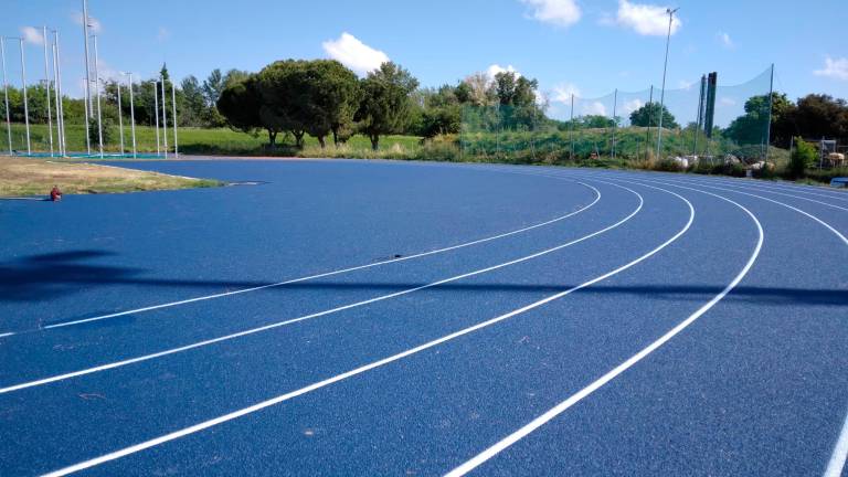 La pista di atletica blu, nuova di zecca La pista di atletica blu, nuova di zecca