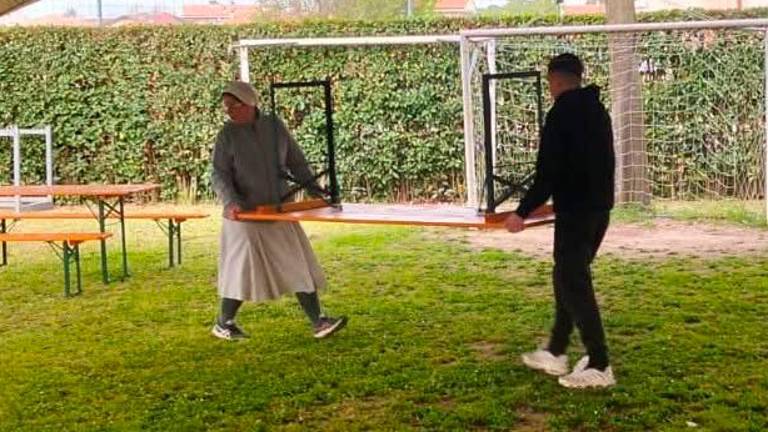 Suor Chiara mentre sistema un tavolo