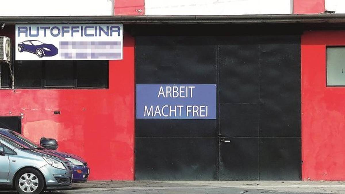 Cartello shock simbolo dei lager all'ingresso dell'officina meccanica