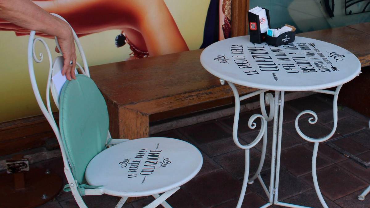 Le scritte visibili in uno dei tavolini del locale e poi coperte dopo aver ricevuto una multa