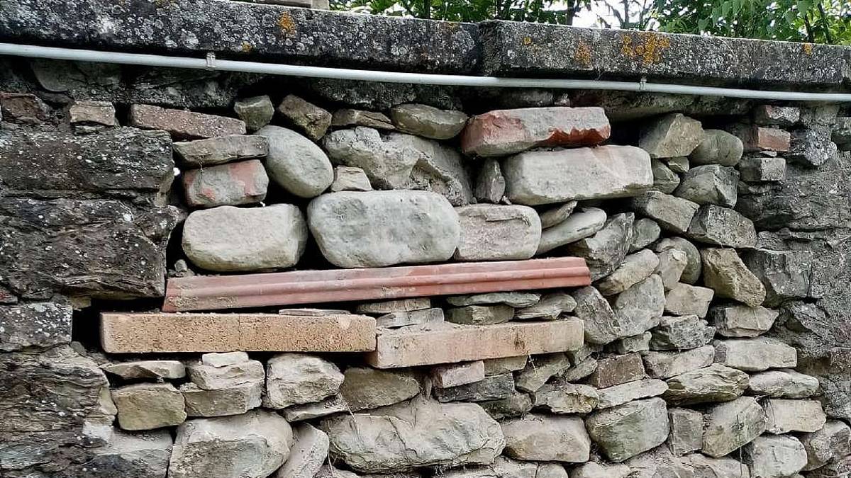 Lavori fai da te al muro del cimitero di Colonnata