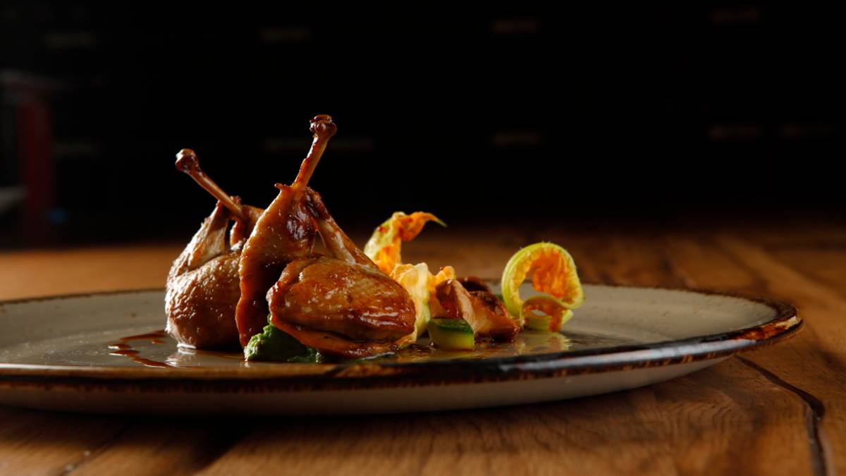 Petto e coscia di quaglia glassati, con galletti gialli e fiori di zucca