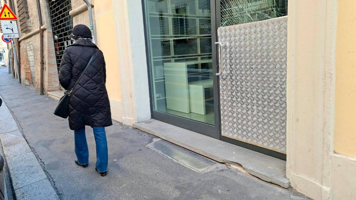 La vetrata con i segni dell’assalto e il tombino usato come ariete foto blaco