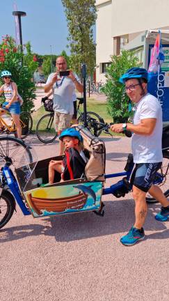 Simone Tura sulla cargo bike insieme al piccolo Davide durante il viaggio dalla Romagna alla Puglia, per sensibilizzare sulle malattie rare