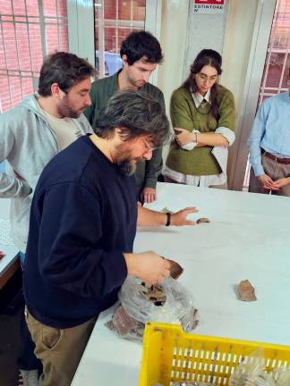 Il prof. Enrico Cirelli e gli studenti al lavoro nel deposito archeologico.