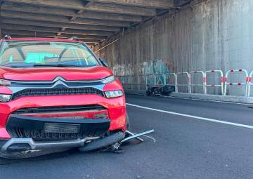 La ruota anteriore e la forcella della moto incastrati sotto l’auto