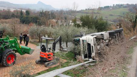 Dall’alto, il camion ribaltato e Vito Pezzino che indica la ghiaia che si è riversata sul suo terreno dove si trovava poco prima dell’incidente