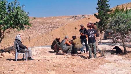 Ali, palestinese di 86 anni seduto di fronte a un gruppo di coloni che banchettano sulle macerie della sua casa demolita