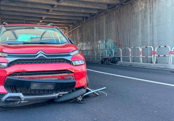 La ruota anteriore e la forcella della moto incastrati sotto l’auto