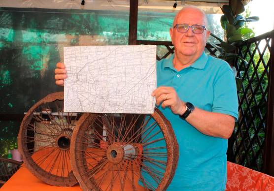 Antonio Baldini con le ruote dell’aereo e una mappa della zona dove si trovava la pista di decollo e atterraggio
