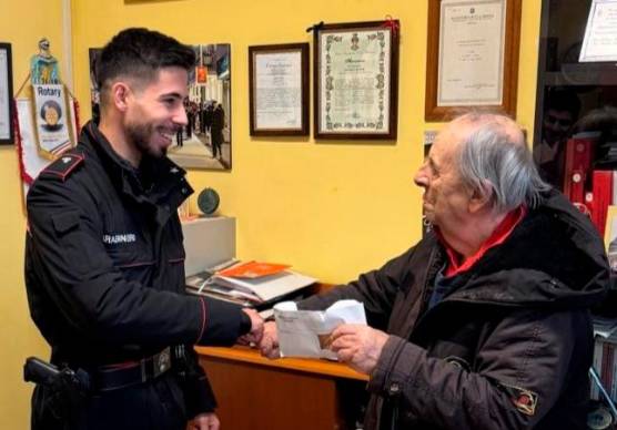 L’uomo mentre riceve dai carabinieri la busta che aveva smarrito