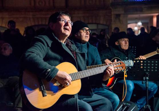 I partecipanti all’evento assieme al vescovo Anselmi e i testi delle canzoni proiettati sul Duomo (Morosetti)