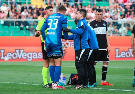 Jonathan Klinsmann si rialza sostenuto dal medico Antonio Argentoni e dall’arbitro Giuseppe Collu dopo l’intervento violento di Filippo Ranocchia al 93’ di Palermo-Cesena