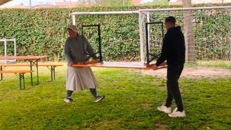 Suor Chiara mentre sistema un tavolo