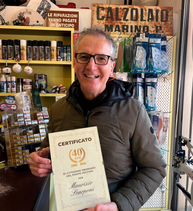 Maurizio Scarponi nel suo negozio, alle spalle l’insegna storica del suo maestro