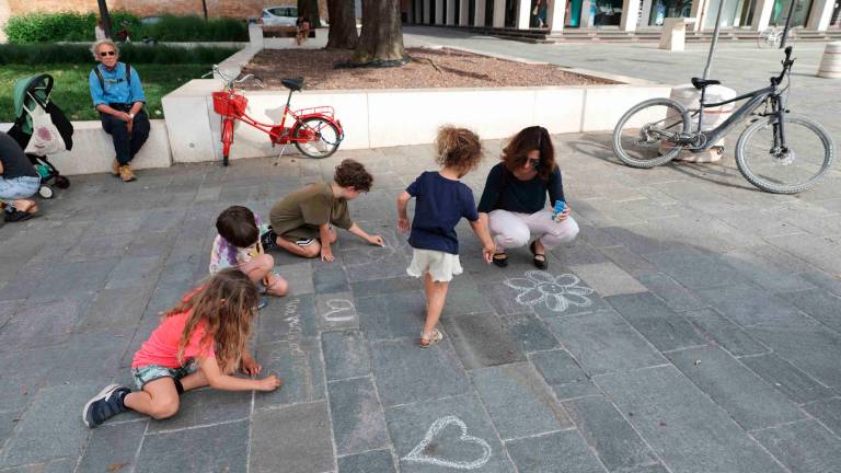 Bambine e bambini impegnati coi gessetti in piazza Bufalini