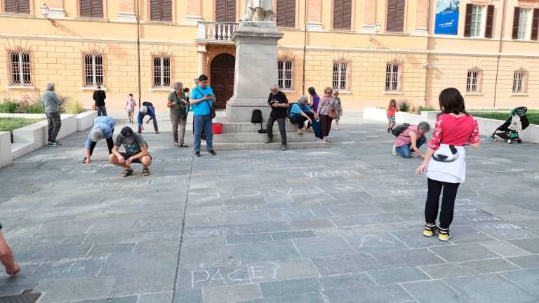 Cesena, bimbi e genitori con Mariangela Gualtieri fanno la “rivoluzione dei gessetti” per Gaza con 200 frasi e disegni sulle piazze davanti alla biblioteca