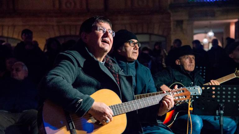 I partecipanti all’evento assieme al vescovo Anselmi e i testi delle canzoni proiettati sul Duomo (Morosetti)