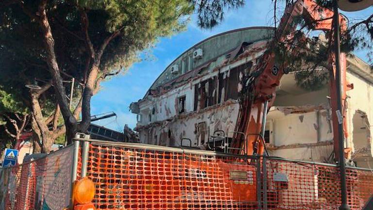 Il palazzo in corso di demolizione e in bianco e nero le fasi di costruzione