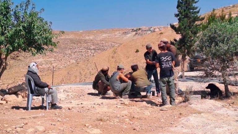 Ali, palestinese di 86 anni seduto di fronte a un gruppo di coloni che banchettano sulle macerie della sua casa demolita