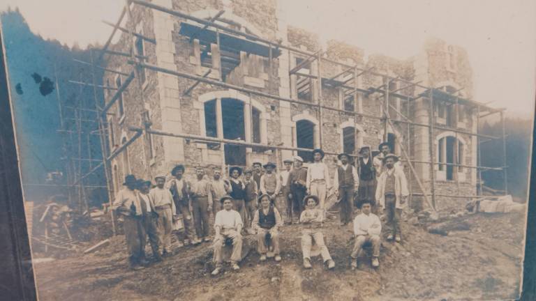 Una foto che ritrae un gruppo di persone davanti a una casa in costruzione. Tra queste persone dovrebbe esserci il bisnonno di Miro Mini