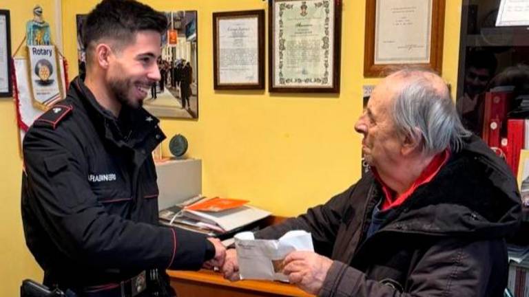 L’uomo mentre riceve dai carabinieri la busta che aveva smarrito