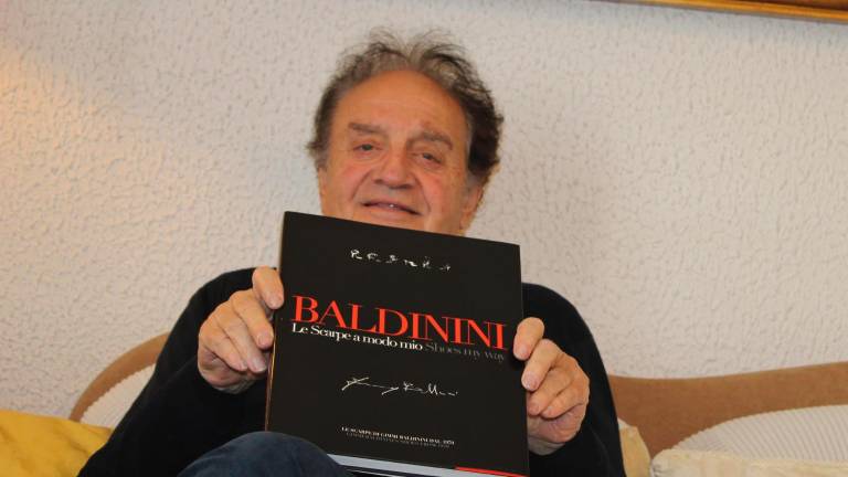 Gimmi Baldinini con il volume che ne ripercorre la carriera