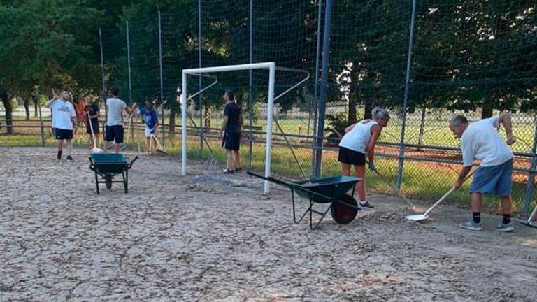 Volontari al lavoro al campo dopo l’alluvione